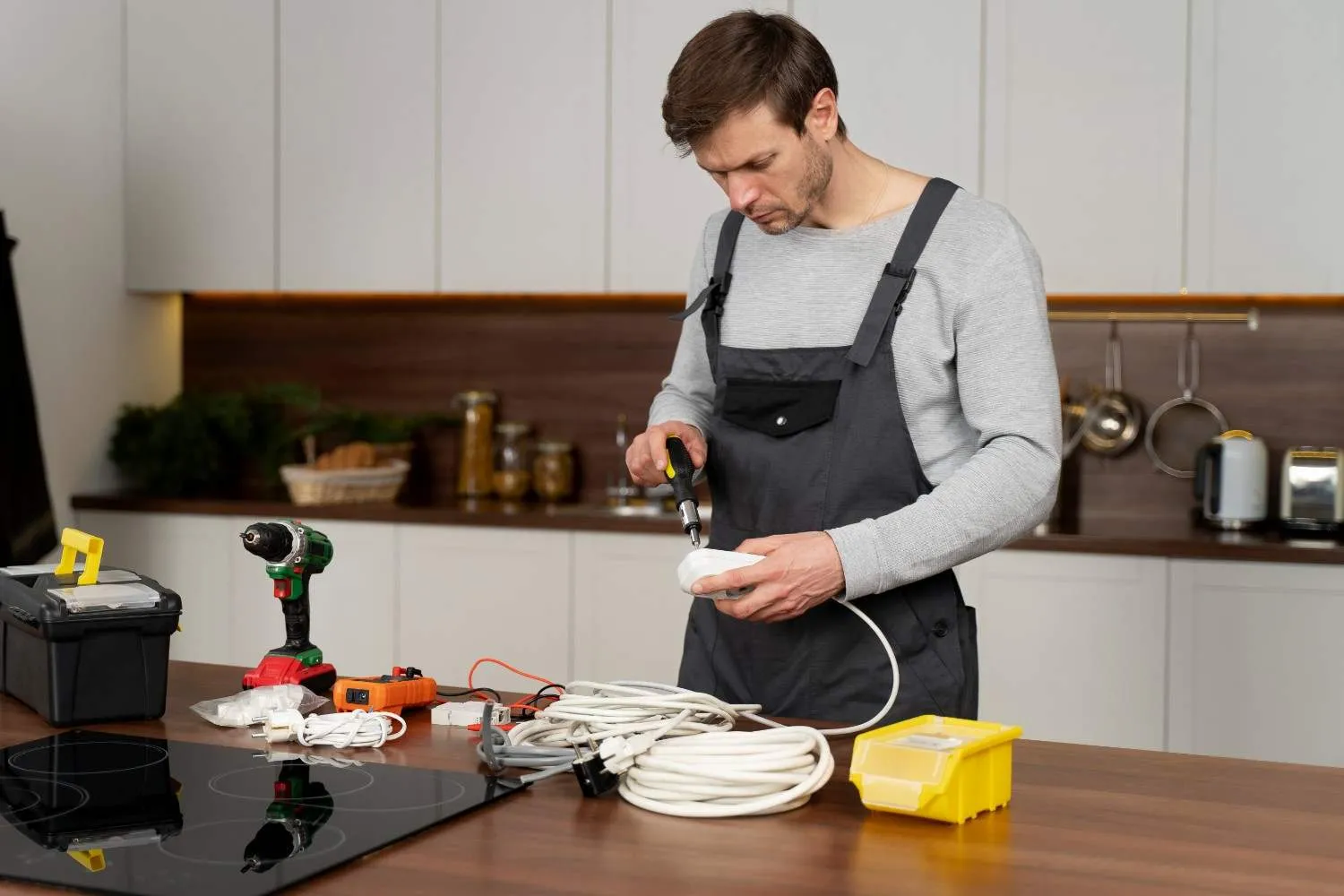 Technician checking appliance wiring on a kitchen counter